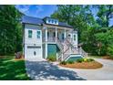 White two-story home with a metal roof, front porch, and landscaping at 4858 Marshwood Dr, Hollywood, SC 29449