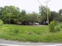 Overgrown yard with large trees and a house in the background at 571 Main Rd, Johns Island, SC 29455