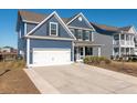 Two-story home with blue siding, white garage door, and driveway at 602 Yellow Leaf Ln, Summerville, SC 29486