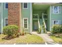 Condo building entrance with stairs and well-manicured landscaping at 6240 April Pine Cir # B, North Charleston, SC 29406