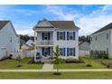 Two-story white house with blue shutters and a charming front porch at 645 Blueway Ave, Summerville, SC 29486