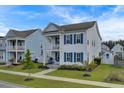Two-story white house with blue shutters, charming porch, and landscaped yard at 645 Blueway Ave, Summerville, SC 29486