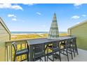 Beachfront deck with table, chairs, and umbrella at 7000 Palmetto Dr # 12E, Isle of Palms, SC 29451