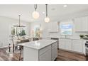 Modern kitchen with white cabinets, island, stainless steel appliances, and hardwood floors at 747 Meadowbrook Ln, Summerville, SC 29486