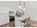 Modern kitchen with white cabinets, island, stainless steel appliances, and hardwood floors at 747 Meadowbrook Ln, Summerville, SC 29486