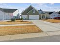 Two-car garage and driveway, green house with landscaping at 1104 Cooper Point St, Summerville, SC 29485