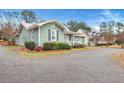 Side view of a charming green house with a metal roof and well-maintained landscaping at 2007 Central Ave, Summerville, SC 29483