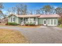 Quaint green house with a metal roof, front porch, and attached garage at 2007 Central Ave, Summerville, SC 29483