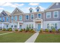 Townhouses with gray and beige siding, well-manicured lawns, and sidewalks at 264 Godwit Dr, Summerville, SC 29486