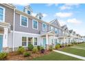 Townhouses with gray and beige siding, landscaping, and a paved walkway at 264 Godwit Dr, Summerville, SC 29486