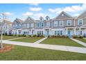 Row of townhouses with gray and beige siding, lush lawns, and sidewalks at 264 Godwit Dr, Summerville, SC 29486