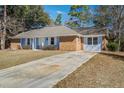 Charming single story home featuring a brick exterior, blue accents, and a long driveway at 303 Longleaf Rd, Summerville, SC 29486