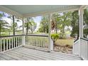 Inviting front porch with wooden flooring and a view of the street and trees at 538 River Rd, Johns Island, SC 29455