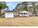 Ranch style brick home with a white garage door and front porch at 127 Roberts Rd, Summerville, SC 29483