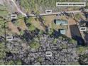 Aerial view of property showing home, detached garage, and pond at 151 Powerhouse Rd, Ridgeville, SC 29472