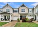 Two-story tan townhome with a front porch, landscaping, and a 2-car garage at 162 Kirkland St, Goose Creek, SC 29445
