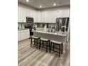 Modern kitchen with white cabinets, granite island, and stainless steel appliances at 493 Trotters Ln # 116, Moncks Corner, SC 29461