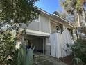 Front view of elevated house, gray siding, white railings, and landscaping at 61 Twin Oaks Ln, Isle of Palms, SC 29451