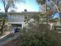 Side view of gray house with white stairs and mature landscaping at 61 Twin Oaks Ln, Isle of Palms, SC 29451