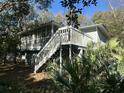 Elevated screened porch with wooden stairs and lush green surroundings at 61 Twin Oaks Ln, Isle of Palms, SC 29451