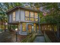 Unique treehouse home at dusk, showcasing its elevated design and surrounding nature at 7 Dunecrest Trace, Seabrook Island, SC 29455