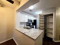 Kitchen boasts granite countertops, white cabinets, and pantry at 1530 Fort Johnson Rd # 2 K, Charleston, SC 29412