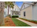 Quaint yellow house exterior with walkway, palm trees, and manicured lawn at 1583 Paradise Lake Dr, Mount Pleasant, SC 29464