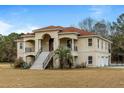 Two-story house with stucco siding, red tile roof, and a large yard at 4712 Westervelt Rd, Meggett, SC 29449