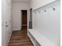 A hallway with white wainscoting, built-in bench, and hardwood floors at 8700 Forte Dr, North Charleston, SC 29406