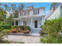 Two-story light blue house with front porch, steps, and well-manicured garden at 11 Perry St, Charleston, SC 29403