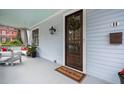 Bright porch with wooden door, a wreath, and cozy seating area at 11 Perry St, Charleston, SC 29403