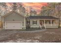 Green house with a white garage door and walkway leading to the front door at 1374 Leisure Dr, Summerville, SC 29486