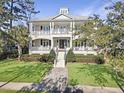 Two-story home with white brick facade, metal roof, and large front porch at 204 King George St, Charleston, SC 29492
