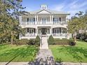 Two-story home with white brick facade, metal roof, and large front porch at 204 King George St, Charleston, SC 29492