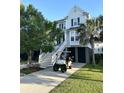 Two-story house with a golf cart in the driveway at 213 Clouter Creek Dr, Wando, SC 29492