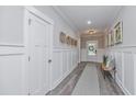 Bright entryway with white wainscoting, wood-look tile flooring, and a bench at 270 Darby Meadow Ln, Ridgeville, SC 29472