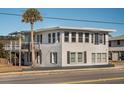 Two-story beach house with white siding, black shutters, and a deck at 405 Palmetto Blvd, Edisto Island, SC 29438