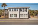 Two-story beach house with white siding, black shutters, and a deck at 405 Palmetto Blvd, Edisto Island, SC 29438
