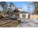 House exterior with a landscaped yard, driveway, and wooden fence at 407 Kingbird Road, Ladson, SC 29456