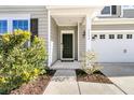 Black front door with a white trim and bushes on both sides at 9736 Black Willow Ln, Ladson, SC 29456