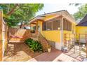 Yellow cottage with hammock, deck, and tropical landscaping at 420 E Erie Ave, Folly Beach, SC 29439