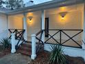 Charming front porch with black metal railings and modern lighting at 488 Society Rd, McClellanville, SC 29458