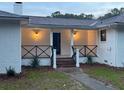 Inviting front porch features brick steps and stylish black railings at 488 Society Rd, McClellanville, SC 29458