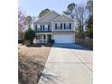 Two-story house with beige siding, white garage door, and a porch at 611 Resinwood Rd, Moncks Corner, SC 29461