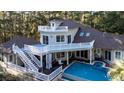 House with a pool and large deck, surrounded by lush trees at 6124 Rudder Ln, Awendaw, SC 29429