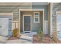 Front door entrance to a townhouse with landscaping at 8410 Hidden Bakers Trce, North Charleston, SC 29418