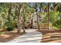 Long driveway leading to charming two-story house nestled among trees at 2942 Seabrook Island Rd, Seabrook Island, SC 29455