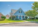 Quaint light blue house with a front porch and neatly kept lawn at 307 Pimpernel St, Summerville, SC 29483