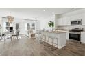 Open concept kitchen with island, stainless steel appliances, and hardwood floors at 8771 Silver Perch Ln, North Charleston, SC 29420