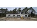 Beige manufactured home with black shutters and a wooden staircase at 126 Addison Rd, Harleyville, SC 29448